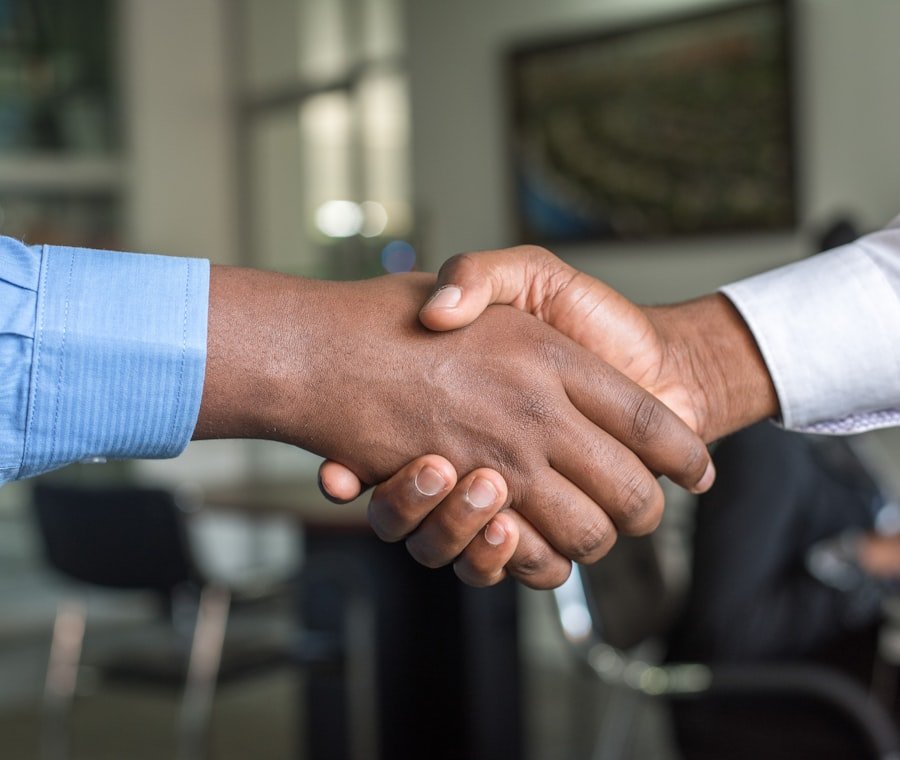 Dunia Travel visa consultant shaking hands with a client in a Dubai office